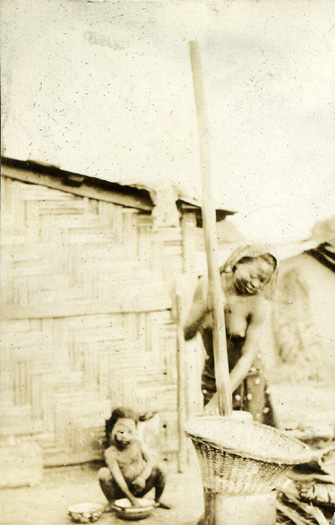 woman grinding grain Photograph of woman grinding grain